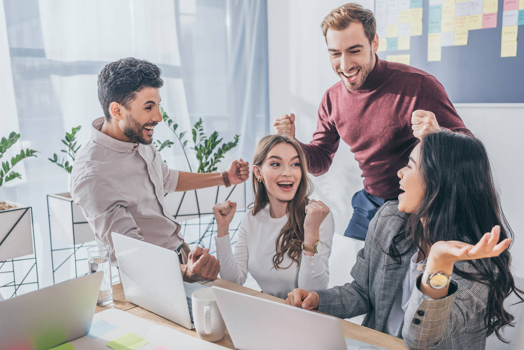 Equipe reunida comemorando resultados em um ambiente de trabalho colaborativo